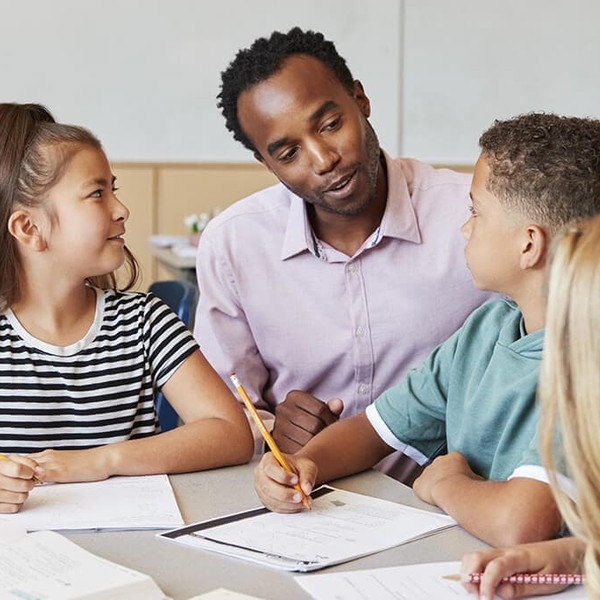 students at table with teacher